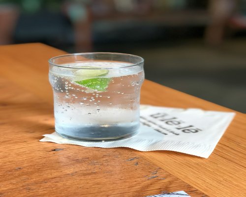 Clear glass of fresh water with a slice of lemon on a wooden table