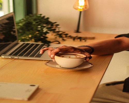 Person working comfortably with a laptop in a well-lit coffee shop in Mexico City