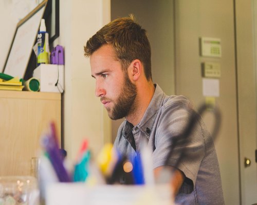 Person standing up stretching gently next to an office desk